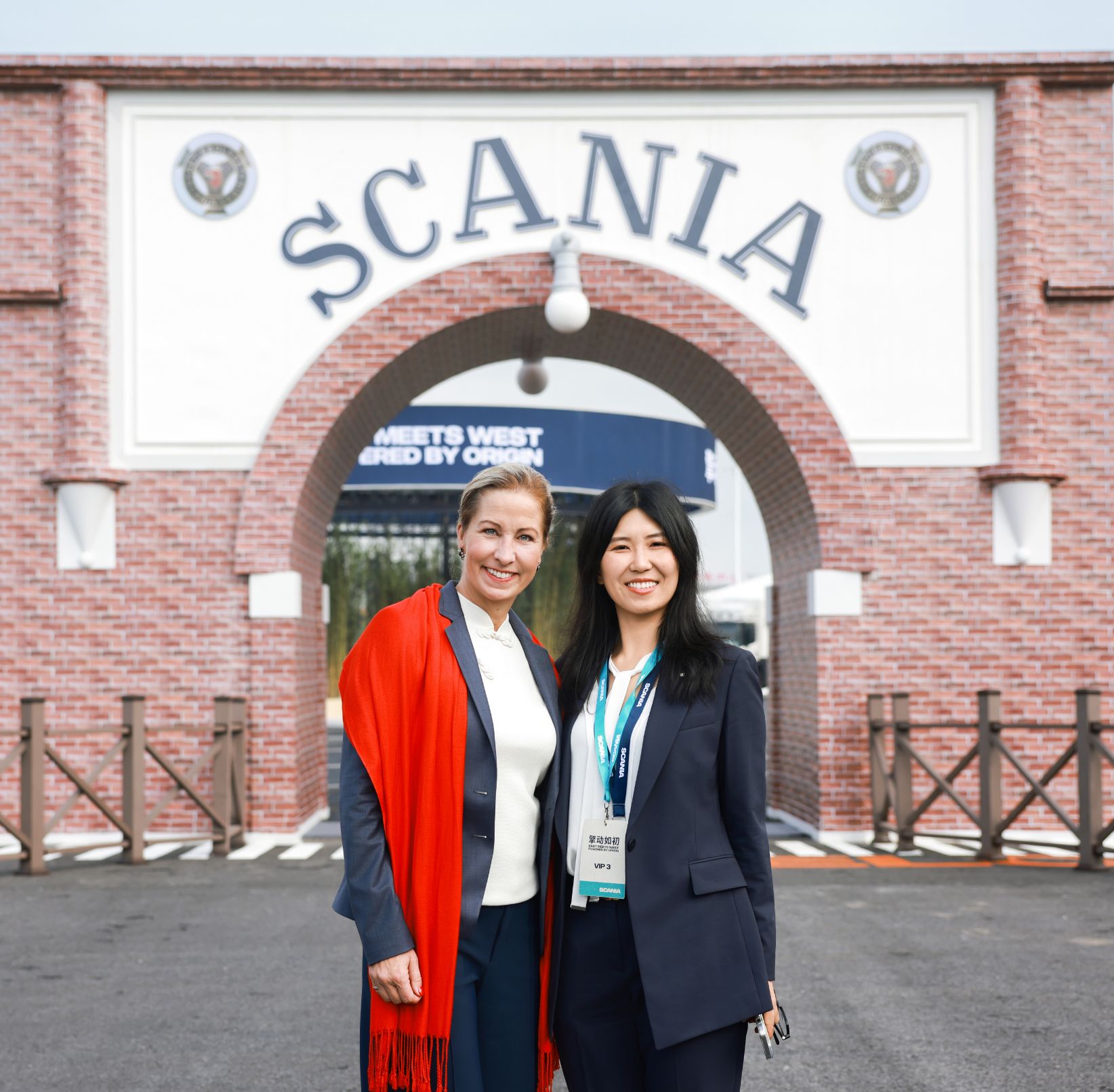 Camilla Dewoon (links) und Zita Shao (rechts), Senior Corporate Communication Manager, vor dem historischen Logo von Scania in Rugao.